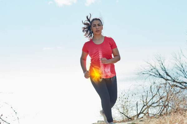 Shot of an attractive young woman running outdoors with her hip injury highlighted